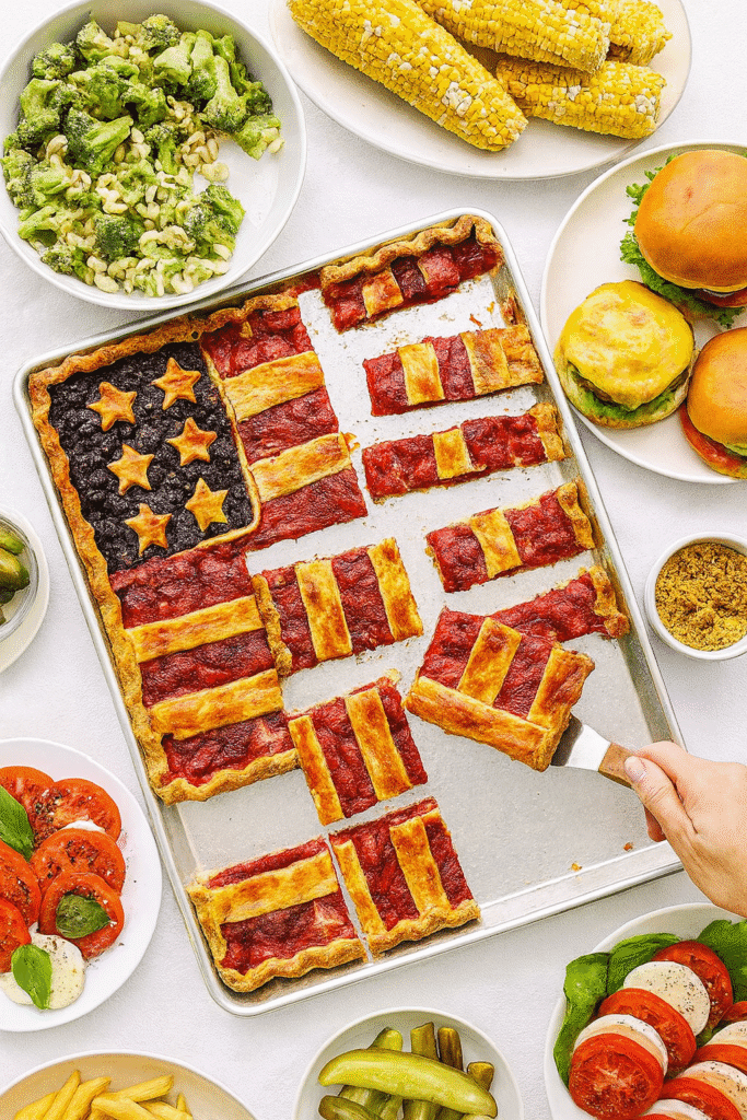American Flag slab pie on a holiday buffet table with several slices missing showing an easy crowd pleasing patriotic dessert
