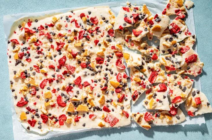 Family-friendly Greek yogurt bark snack with hands reaching for frozen pieces
