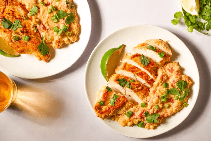 Close up plate of easy chicken skillet dinner with sliced seared chicken over creamy Southwest corn, served with rice.