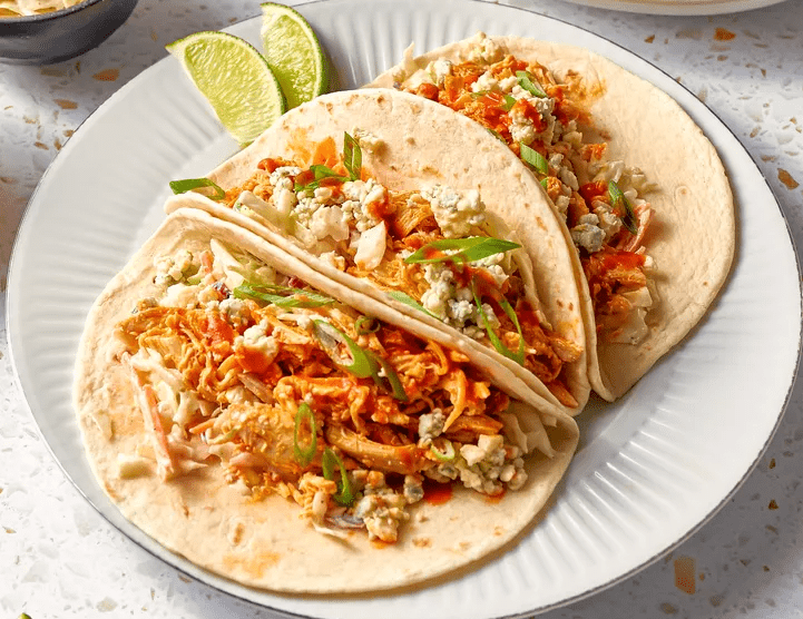 Quick Buffalo chicken tacos filled with shredded chicken, creamy coleslaw, and blue cheese crumbles served for dinner