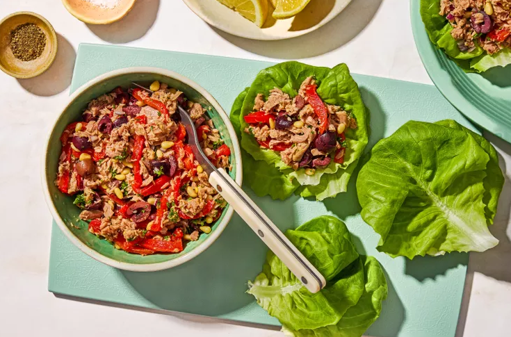 Close up of chunky Italian tuna salad with roasted red peppers kalamata olives onion and toasted nuts