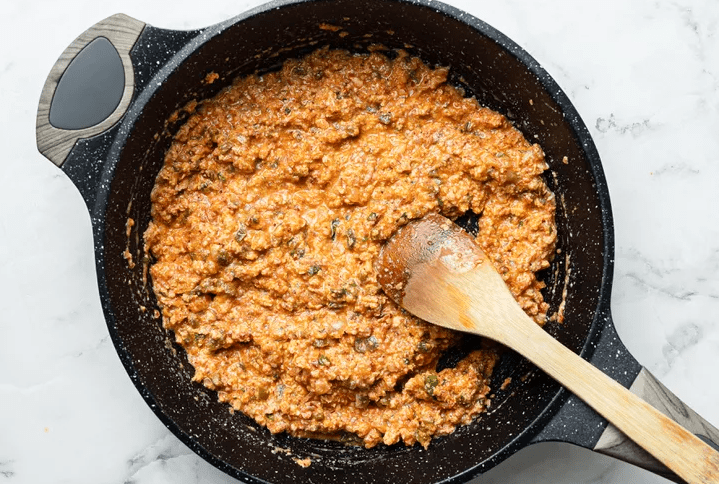 Beaten eggs gently folded into a tomato and pepper mixture in a pan to make soft menemen