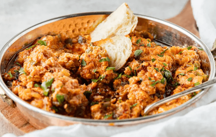 Garnish the menemen with drizzles of the flavored oil and chopped parsley leaves scattered on top. 