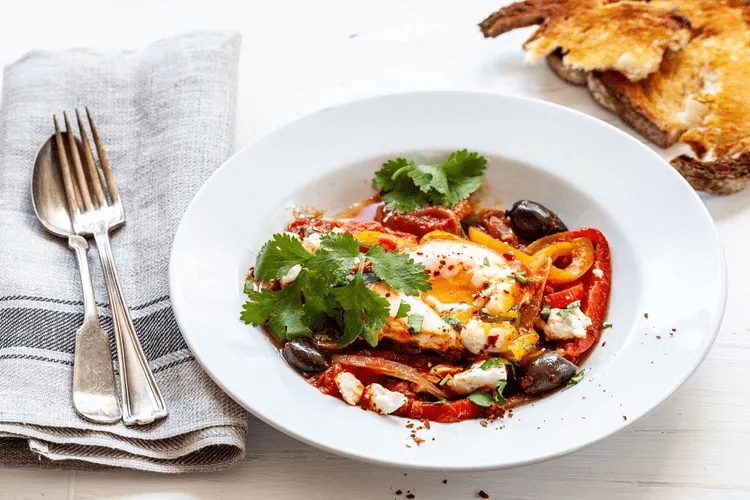 A Shakshuka with Feta, Olives, and Peppers is ready to serve