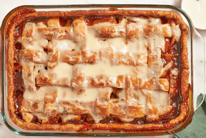 Sweet potato sonker cooling on a wire rack with a serving in a bowl and a small pitcher of milk dip