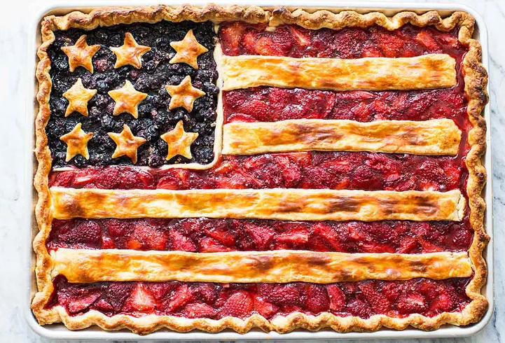 American Flag Pie slab dessert on a sheet pan with strawberry and blueberry filling and flaky sour cream crust for Fourth of July