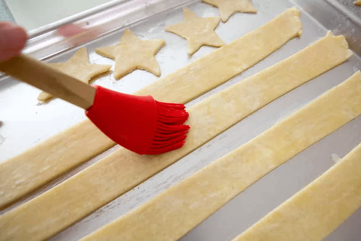 Dough strips and star cutouts on a work surface ready to top an American Flag slab pie