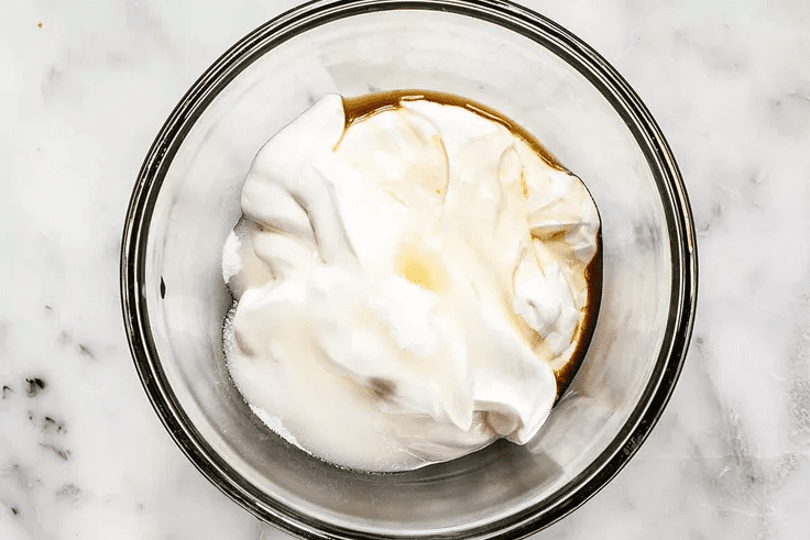 In a bowl, stiring sour cream, sugar, and vanilla extract