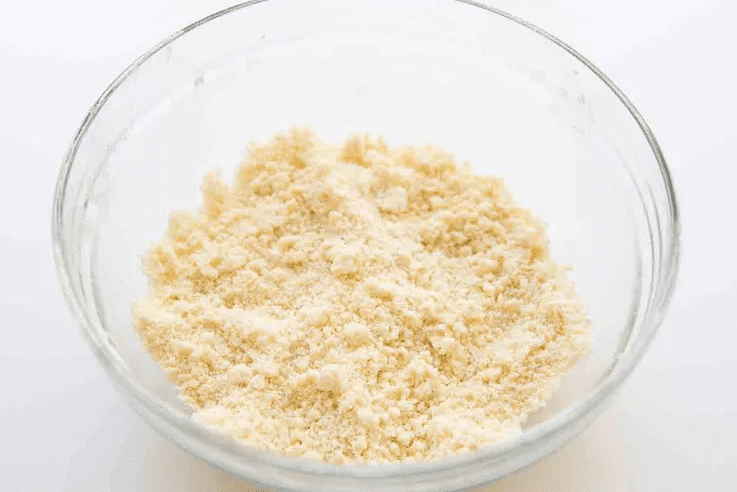 Tart crust dough mixture with sandy crumbs and small butter pieces before adding egg