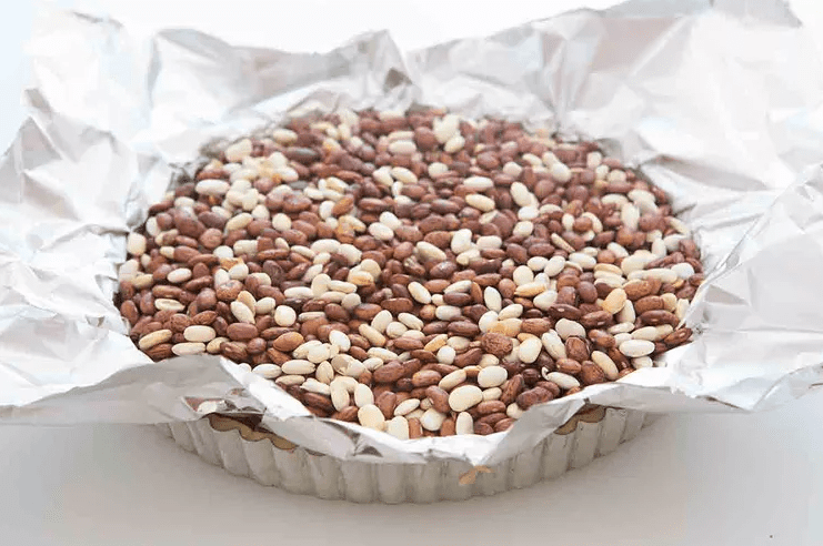 Blind baking a tart crust lined with foil and filled with pie weights