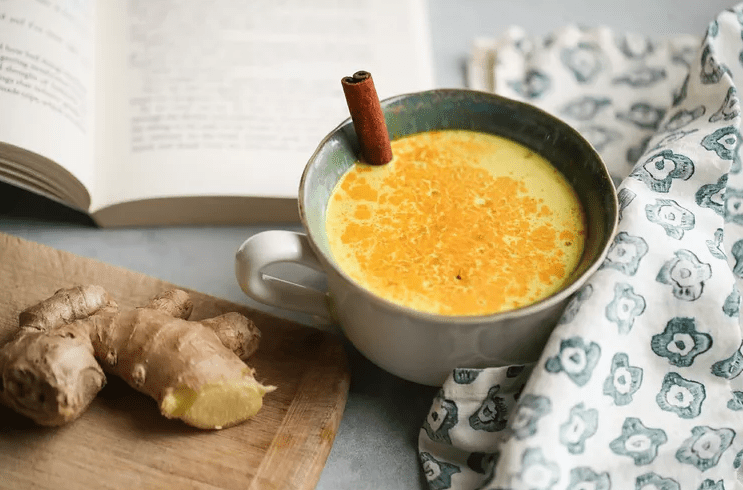 A mug of coconut with turmeric and ginger on the table