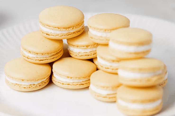 several assembled lemon macaron showing crisp shell, chewy center, and creamy lemon buttercream filling.